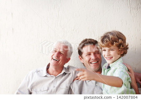 Pointing, family and grandpa, father and child in home for bonding, happy relationship and generations. Wall background, smile and grandfather, boy and dad relaxing in garden with view on weekend 142007804