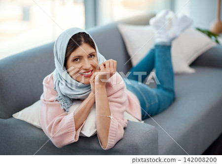 Muslim, woman and lounge in living room for weekend, relax and happiness on sofa in apartment. Hijab, peace and smile in house for morning zen, wellness and inside for rest, break and reset. Muslim, woman and lounge in living room for weekend, relax and happiness on sofa in apartment. Hijab, peace and smile in house for morning zen, wellness and inside for rest, break and reset. 142008200