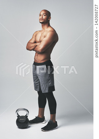 Black man, portrait and kettlebell in studio, confidence and shirtless for workout or exercise. Male person, athlete and weightlifting for muscle progress on gray background, tough and challenge Black man, portrait and kettlebell in studio, confidence and shirtless for workout or exercise. Male person, athlete and weightlifting for muscle progress on gray background, tough and challenge 142008727