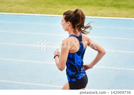 Running, race track and woman for fitness, exercise and workout for sport outdoor by grass or field. Stadium, runner and athlete for wellness and gym for cardio, training and health in back view Running, race track and woman for fitness, exercise and workout for sport outdoor by grass or field. Stadium, runner and athlete for wellness and gym for cardio, training and health in back view 142009736