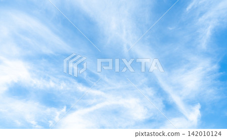 Bright blue sky filled with wispy white clouds creating a textured atmospheric pattern. Bright blue sky filled with wispy white clouds creating a textured atmospheric pattern. 142010124