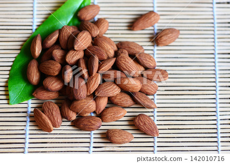 Almonds nuts on wooden with leaf almonds top view background, Roasted almond for snack Almonds nuts on wooden with leaf almonds top view background, Roasted almond for snack 142010716