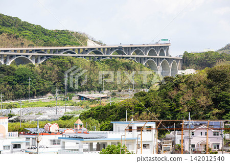 The continuous arch bridges of the Okinawa Expressway and the lush green landscape The continuous arch bridges of the Okinawa Expressway and the lush green landscape 142012540