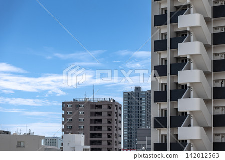 A cityscape lined with modern apartment buildings. A cityscape lined with modern apartment buildings. 142012563