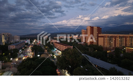 Cityscape at dusk with illuminated buildings and traffic in Almaty Cityscape at dusk with illuminated buildings and traffic in Almaty 142013282