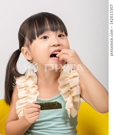 Happy Asian kid holding a piece of seaweed snack, healthy dried seaweed concept for children. Happy Asian kid holding a piece of seaweed snack, healthy dried seaweed concept for children. 142013307