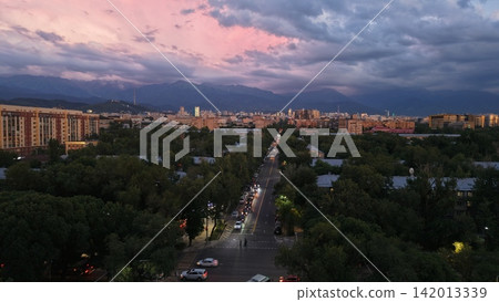 Cityscape at dusk with mountains and colorful sky over urban area Cityscape at dusk with mountains and colorful sky over urban area 142013339
