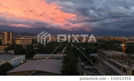 City skyline at sunset with mountains and dramatic clouds in background City skyline at sunset with mountains and dramatic clouds in background 142013358