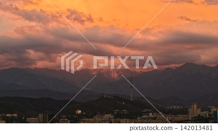 Sunset over mountains with city skyline and telecommunications tower visible Sunset over mountains with city skyline and telecommunications tower visible 142013481