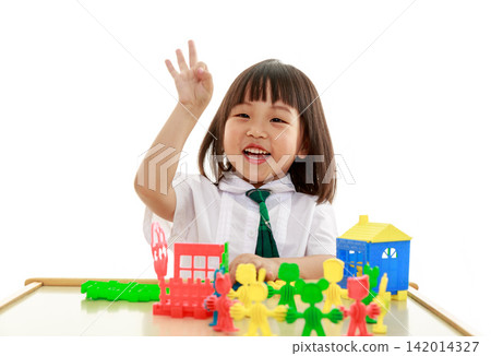 Smiling little girl building a colorful toy house with blocks, creative play and early engineering concept. Smiling little girl building a colorful toy house with blocks, creative play and early engineering concept. 142014327