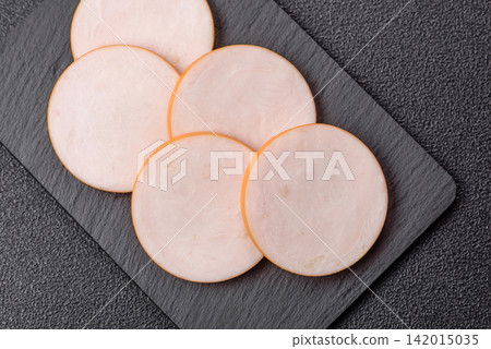 Slices of boiled chicken or pork sausage as an ingredient for home cooking. Sliced boiled sausage Slices of boiled chicken or pork sausage as an ingredient for home cooking. Sliced boiled sausage 142015035