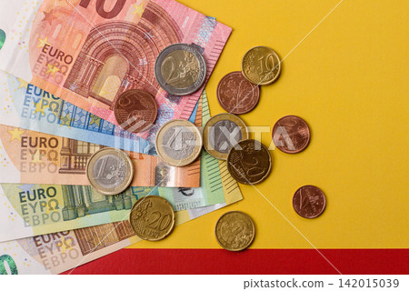 Spain, Spanish euro cash and cent coins against the background of the flag. Euro cash Spain, Spanish euro cash and cent coins against the background of the flag. Euro cash 142015039