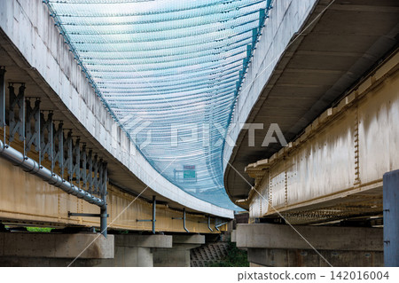 The powerful infrastructure structure and concrete bridge piers viewed from beneath the massive elevated bridge. The powerful infrastructure structure and concrete bridge piers viewed from beneath the massive elevated bridge. 142016004