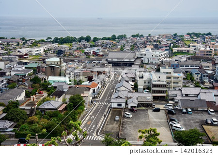 從長崎縣島原市島原城天守閣眺望島原站和有明海的城鎮景觀。 從長崎縣島原市島原城天守閣眺望島原站和有明海的城鎮景觀。 142016323