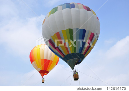 A balloon floating in the blue sky A balloon floating in the blue sky 142016370