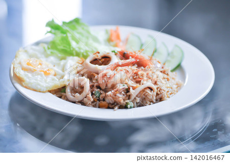 fried rice or stir-fried rice with shrimp , squid and fried egg or sunny side up egg fried rice or stir-fried rice with shrimp , squid and fried egg or sunny side up egg 142016467