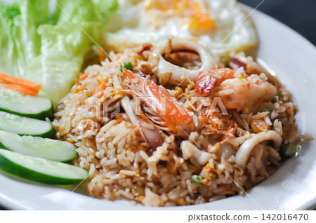 fried rice or stir-fried rice with shrimp , squid and fried egg or sunny side up egg fried rice or stir-fried rice with shrimp , squid and fried egg or sunny side up egg 142016470