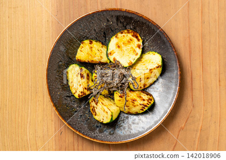Zucchini grilled over charcoal and served with salted kelp. Zucchini grilled over charcoal and served with salted kelp. 142018906