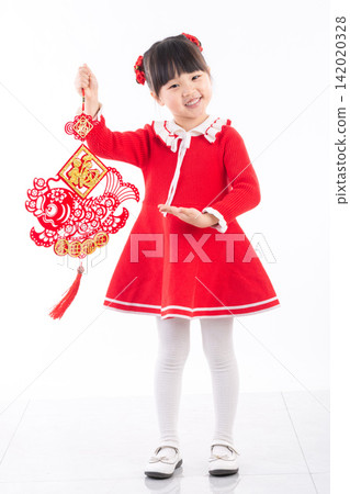 A full length portrait of an Asian girl standing and holding two red Chinese New Year decorations in a white studio. A full length portrait of an Asian girl standing and holding two red Chinese New Year decorations in a white studio. 142020328