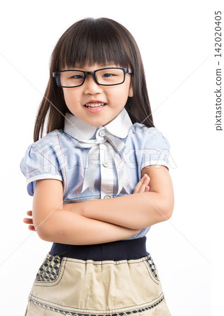 Confident little girl standing with arms crossed and smiling broadly at the camera. 142020405