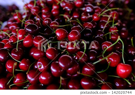 Fresh sweet cherries displayed at local farmers market, ripe summer fruit for healthy snacks, seasonal harvest, natural produce and colorful market food selection Fresh sweet cherries displayed at local farmers market, ripe summer fruit for healthy snacks, seasonal harvest, natural produce and colorful market food selection 142020744