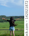 A vertical, full-body shot of a girl with her arms outstretched in a grassland in Tohoku | Stock footage for vertical social media ads 142021872