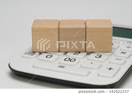 Wooden blocks for 3 characters and copy space arranged on top of the calculator Wooden blocks for 3 characters and copy space arranged on top of the calculator 142022257
