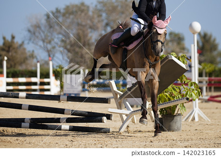 Horse in a jumping fails at the obstacle, the whole obstacle fell, over a jump rider about to fall Horse in a jumping fails at the obstacle, the whole obstacle fell, over a jump rider about to fall 142023165