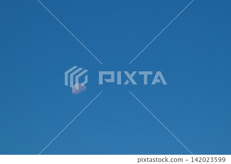 A faint crescent moon against a deep blue sky A faint crescent moon against a deep blue sky 142023599