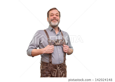 Smiling mature man in traditional lederhosen holding suspenders isolated on white Smiling mature man in traditional lederhosen holding suspenders isolated on white 142024148