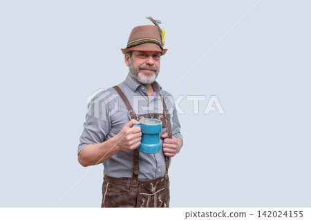 Smiling bearded man in Bavarian outfit holding blue beer mug Smiling bearded man in Bavarian outfit holding blue beer mug 142024155
