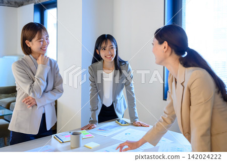 Three businesswomen having a meeting in a conference room. Three businesswomen having a meeting in a conference room. 142024222