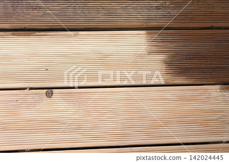 Brown oil for protection of wood by staining. Painting a larch for protecting and pests. Woodworker applying finish to terrace deck board. Repairman varnishing with brush wooden plank floor surface. Brown oil for protection of wood by staining. Painting a larch for protecting and pests. Woodworker applying finish to terrace deck board. Repairman varnishing with brush wooden plank floor surface. 142024445
