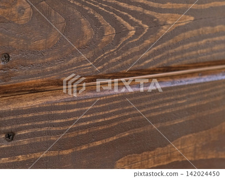 Brown oil for protection of wood by staining. Painting fence for protecting and pests. Woodworker applying finish to pine board box. Repairman varnishing with brush wooden fencing wall plank surface. Brown oil for protection of wood by staining. Painting fence for protecting and pests. Woodworker applying finish to pine board box. Repairman varnishing with brush wooden fencing wall plank surface. 142024450