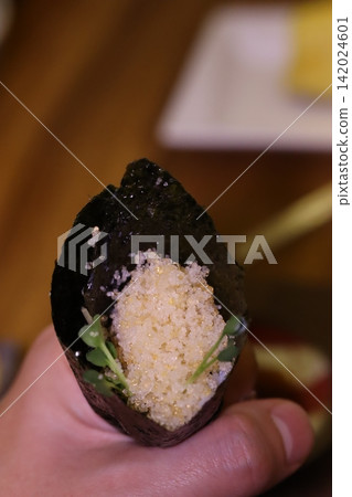 Hand Holding Seaweed-Wrapped Rice Snack Hand Holding Seaweed-Wrapped Rice Snack 142024601