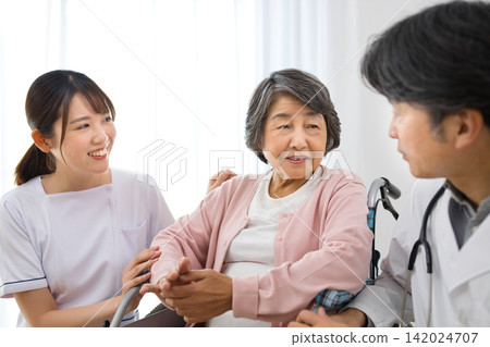 Senior woman in a wheelchair and a medical worker Senior woman in a wheelchair and a medical worker 142024707
