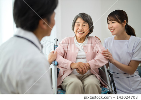 Senior woman in a wheelchair and a medical worker 142024708