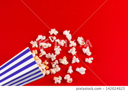 box with popcorn striped in different colors on a red background box with popcorn striped in different colors on a red background 142024825