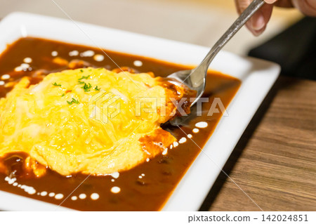 一碗淋著濃稠醬汁的流質煎蛋飯;我正準備用湯匙吃。 一碗淋著濃稠醬汁的流質煎蛋飯;我正準備用湯匙吃。 142024851