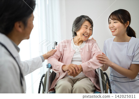 輪椅的資深婦女和醫務工作者 142025011