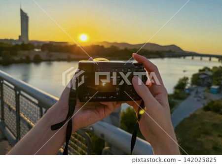 Hands of a man taking photos of solar eclipse with photo camera. Hands of a man taking photos of solar eclipse with photo camera. 142025825