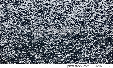 crumpled aluminum foil texture shining silver creases over dark shadows for futuristic packaging and web design backdrop crumpled aluminum foil texture shining silver creases over dark shadows for futuristic packaging and web design backdrop 142025855