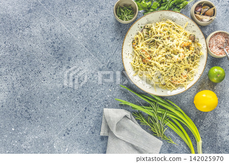 Pasta linguine with mushrooms, shrimps and seafood mussels, cheese and herbs, in ceramic plate on a light gray surface. Pasta linguine with mushrooms, shrimps and seafood mussels, cheese and herbs, in ceramic plate on a light gray surface. 142025970