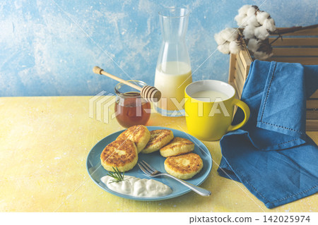 Cottage cheese pancakes, syrniki, ricotta fritters on ceramic plate. Gourmet healthy delicious morning breakfast. Copy space Cottage cheese pancakes, syrniki, ricotta fritters on ceramic plate. Gourmet healthy delicious morning breakfast. Copy space 142025974