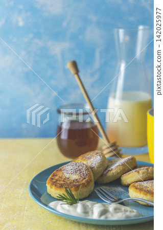 Cottage cheese pancakes, syrniki, ricotta fritters on ceramic plate. Gourmet healthy delicious morning breakfast. Copy space Cottage cheese pancakes, syrniki, ricotta fritters on ceramic plate. Gourmet healthy delicious morning breakfast. Copy space 142025977