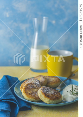 Cottage cheese pancakes, syrniki, ricotta fritters on ceramic plate. Gourmet healthy delicious morning breakfast. Copy space Cottage cheese pancakes, syrniki, ricotta fritters on ceramic plate. Gourmet healthy delicious morning breakfast. Copy space 142025979