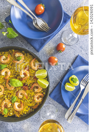 Traditional spanish seafood paella in the fry pan. Dinner served with wine. 142026091