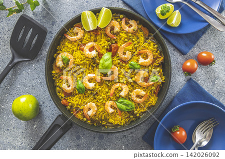 Traditional spanish seafood paella in the fry pan. Dinner served with wine. 142026092