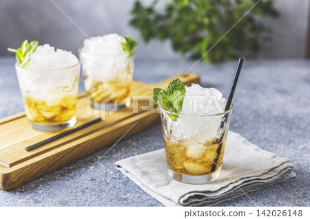 Homemade gourmet fresh Mint Julep alcoholic cocktail on light gray table surface Homemade gourmet fresh Mint Julep alcoholic cocktail on light gray table surface 142026148