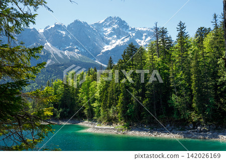 Travel landscape of Zugspitze Alps in Bavaria, Germany, scenic summer nature panorama with forest, Eibsee lake, snow mountains peak. Alpine landscape Travel landscape of Zugspitze Alps in Bavaria, Germany, scenic summer nature panorama with forest, Eibsee lake, snow mountains peak. Alpine landscape 142026169
